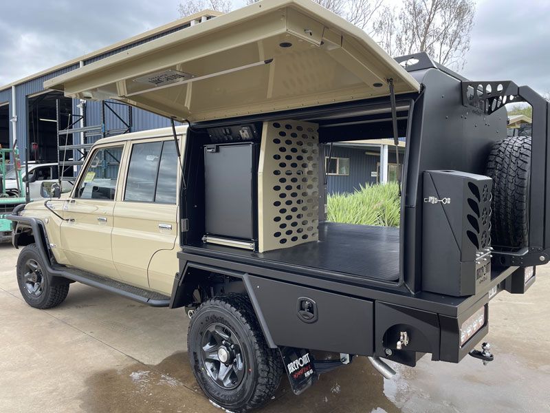 A toyota land cruiser with a dog kennel on top of it.