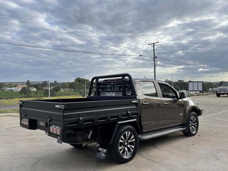 A pickup truck with a flat bed is parked in a parking lot.
