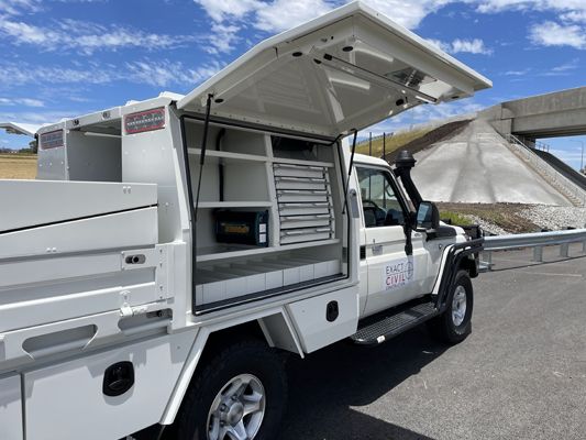 A white truck with the hood open is parked on the side of the road.