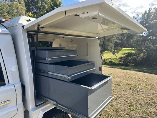 A white truck with drawers in the back of it
