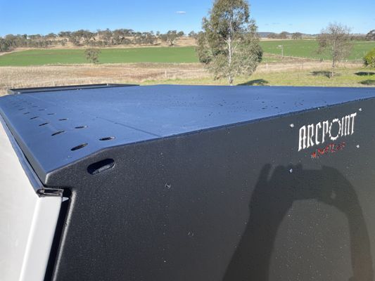 A person is taking a picture of the roof of a truck.