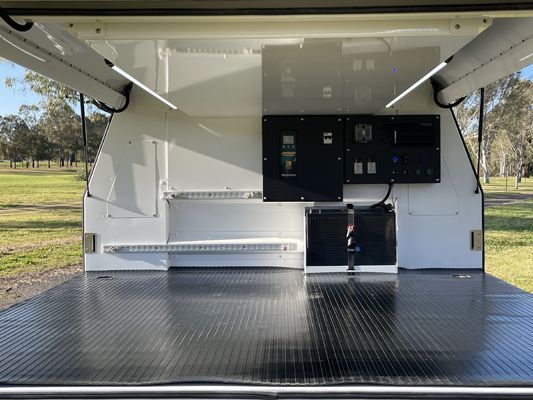 The inside of a white van with the door open and a black floor.