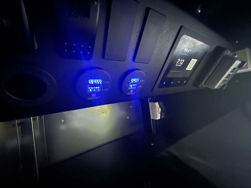 A dashboard of a car with a blue light shining on it