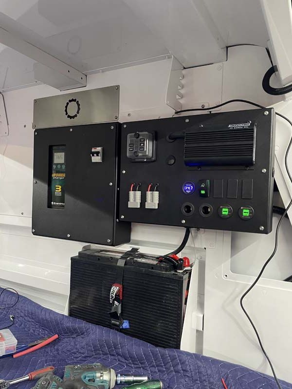 A electrical panel is being installed on the wall of a boat.
