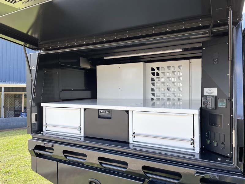 The inside of a truck with drawers and a table.