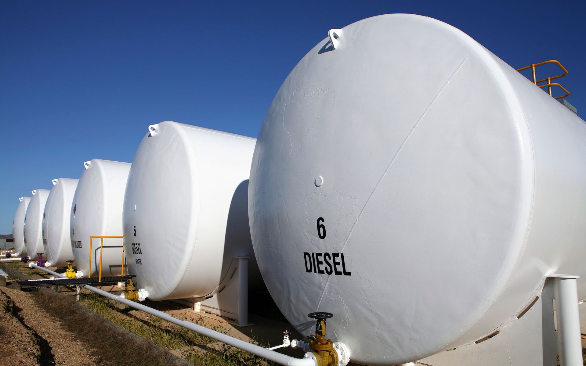 A row of white tanks with diesel written on them