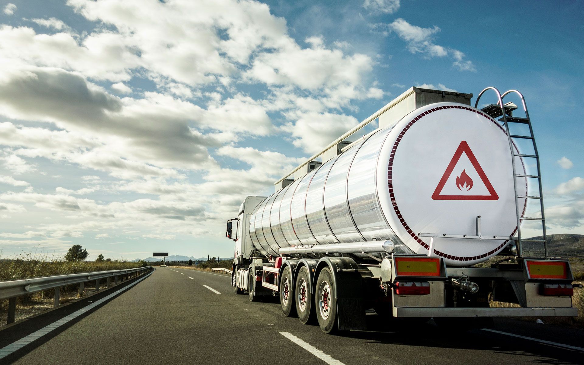 A tanker truck is driving down a highway.