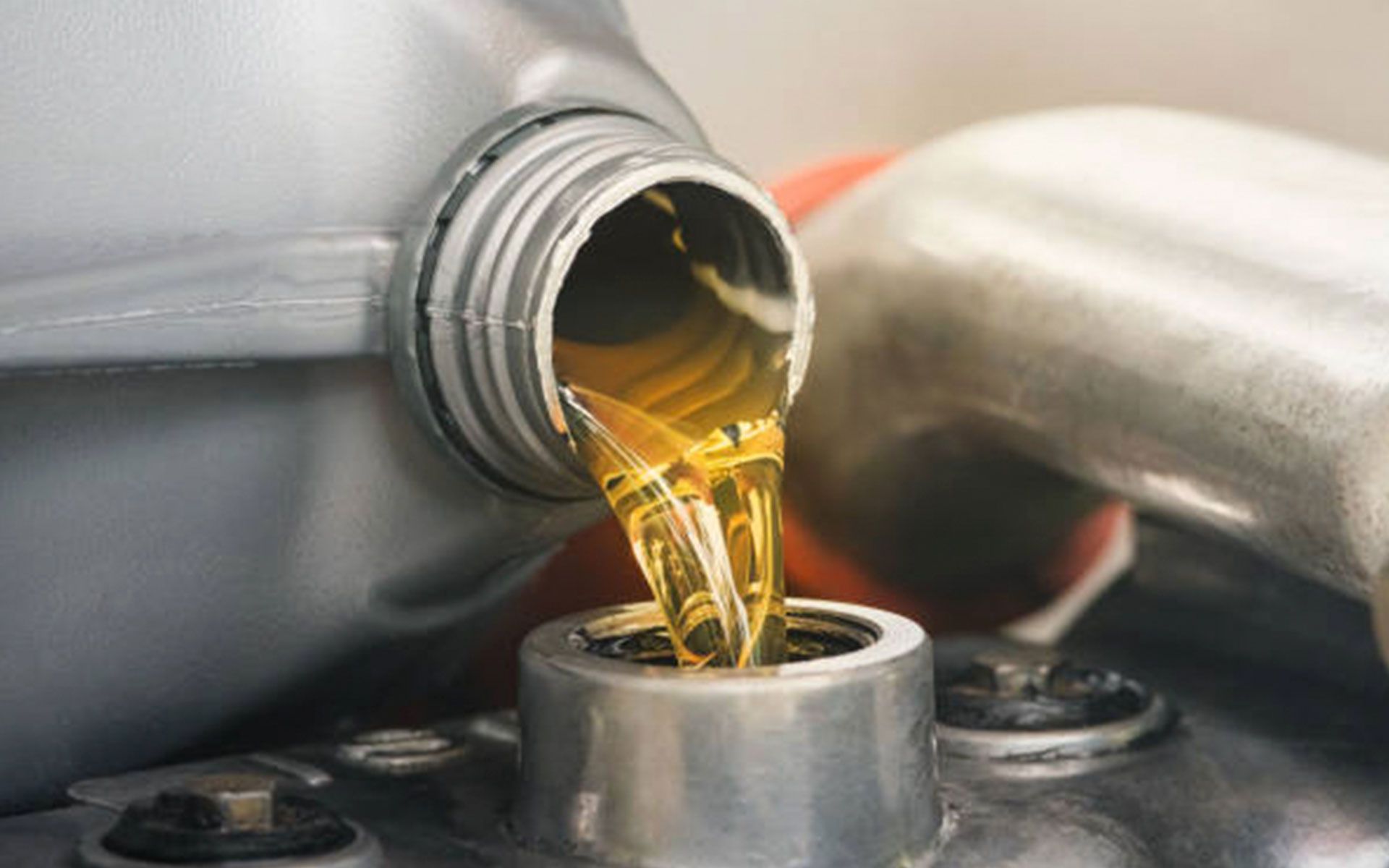 A bottle of oil is being poured into a car engine.