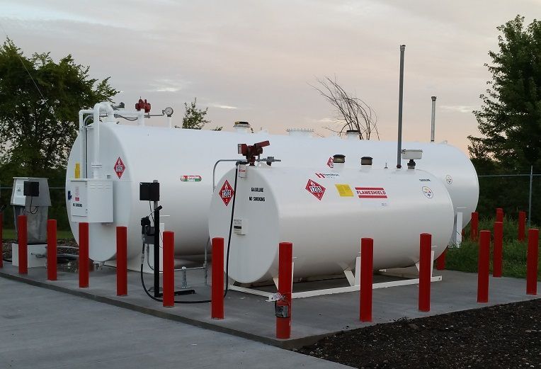 A gas station with a lot of tanks and red poles