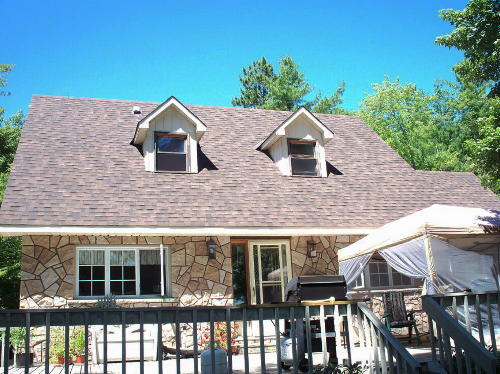 small brick house with gable roof and dormer windows
