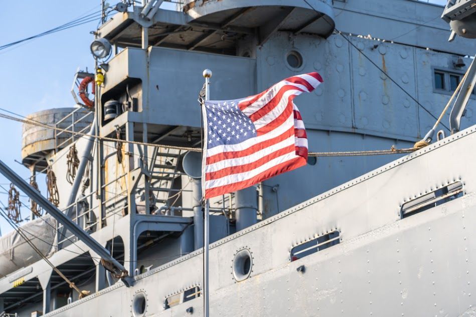 An american flag is flying on the side of a large ship.