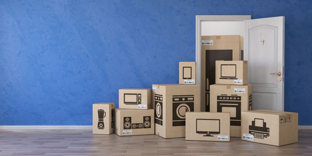 An elderly couple is sitting on the floor in a room with moving boxes.