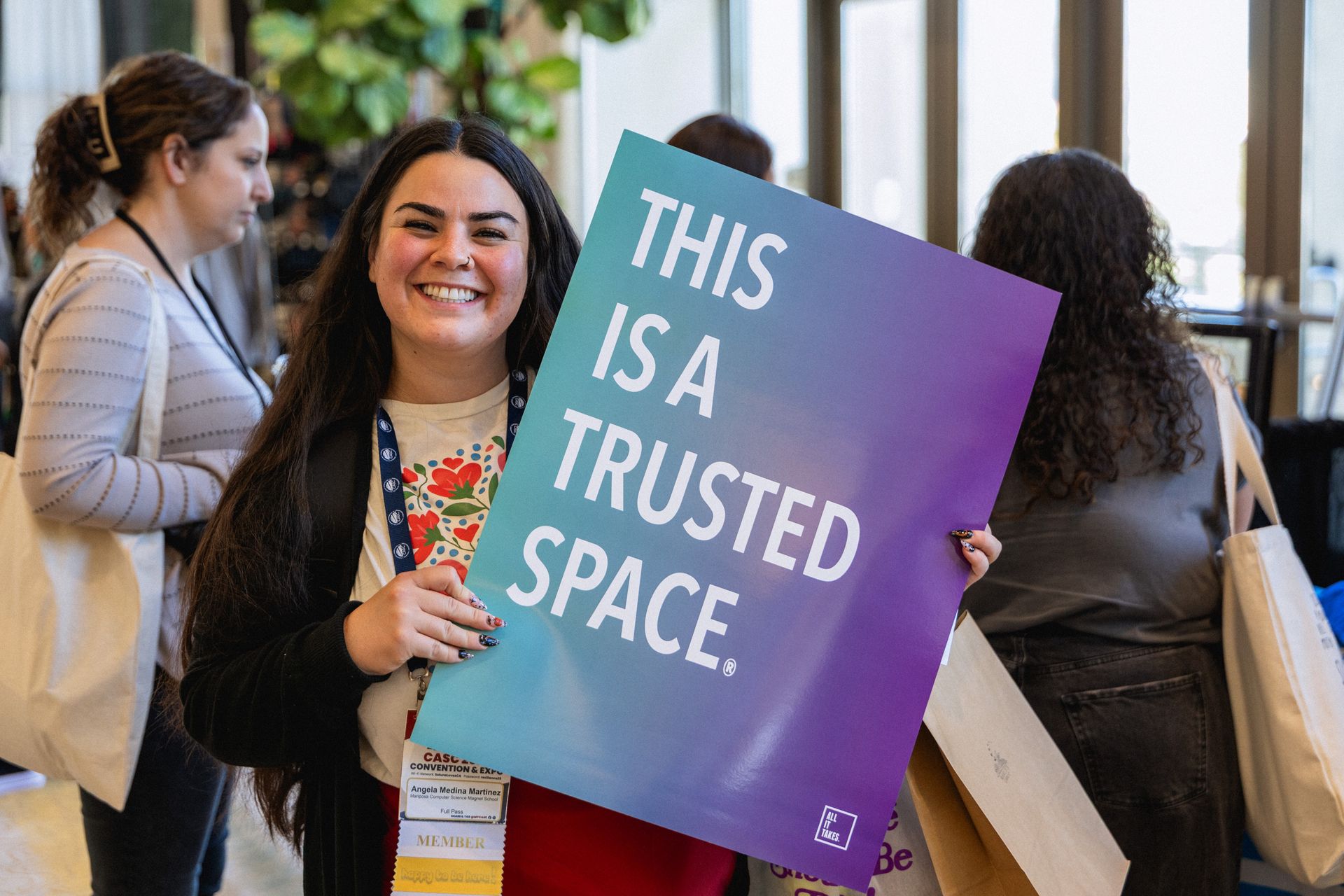 Woman smiles, holds sign: 