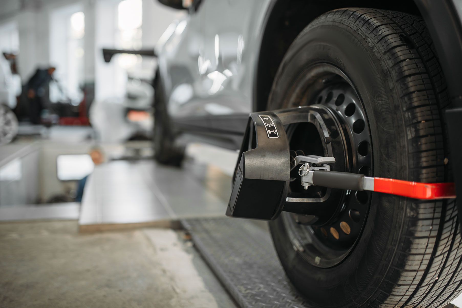 Car wheel with alignment equipment in a repair shop.