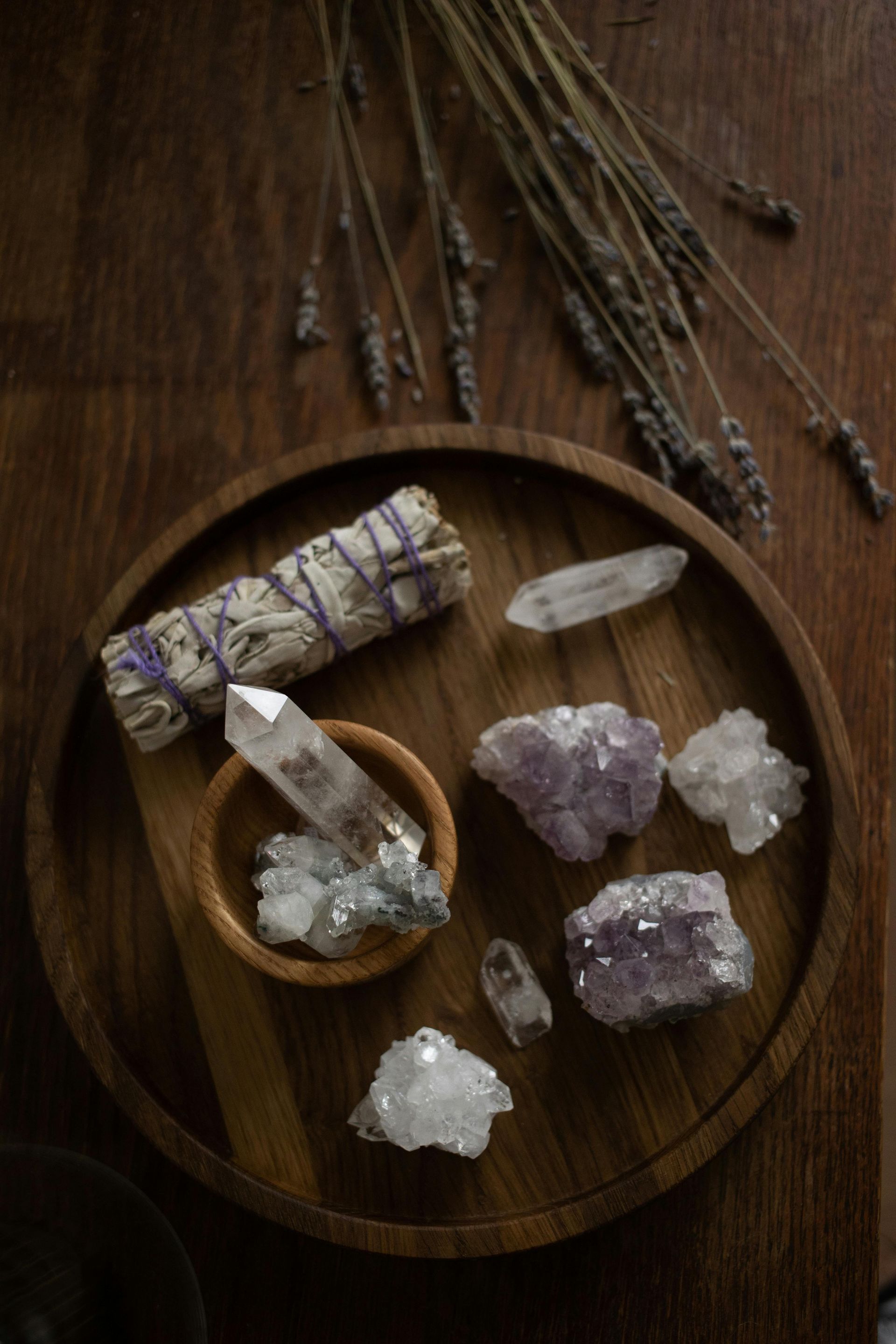 Wooden tray with crystals, sage bundle, and dried lavender.