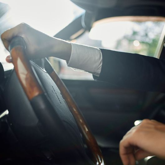 a person is holding the steering wheel of a car