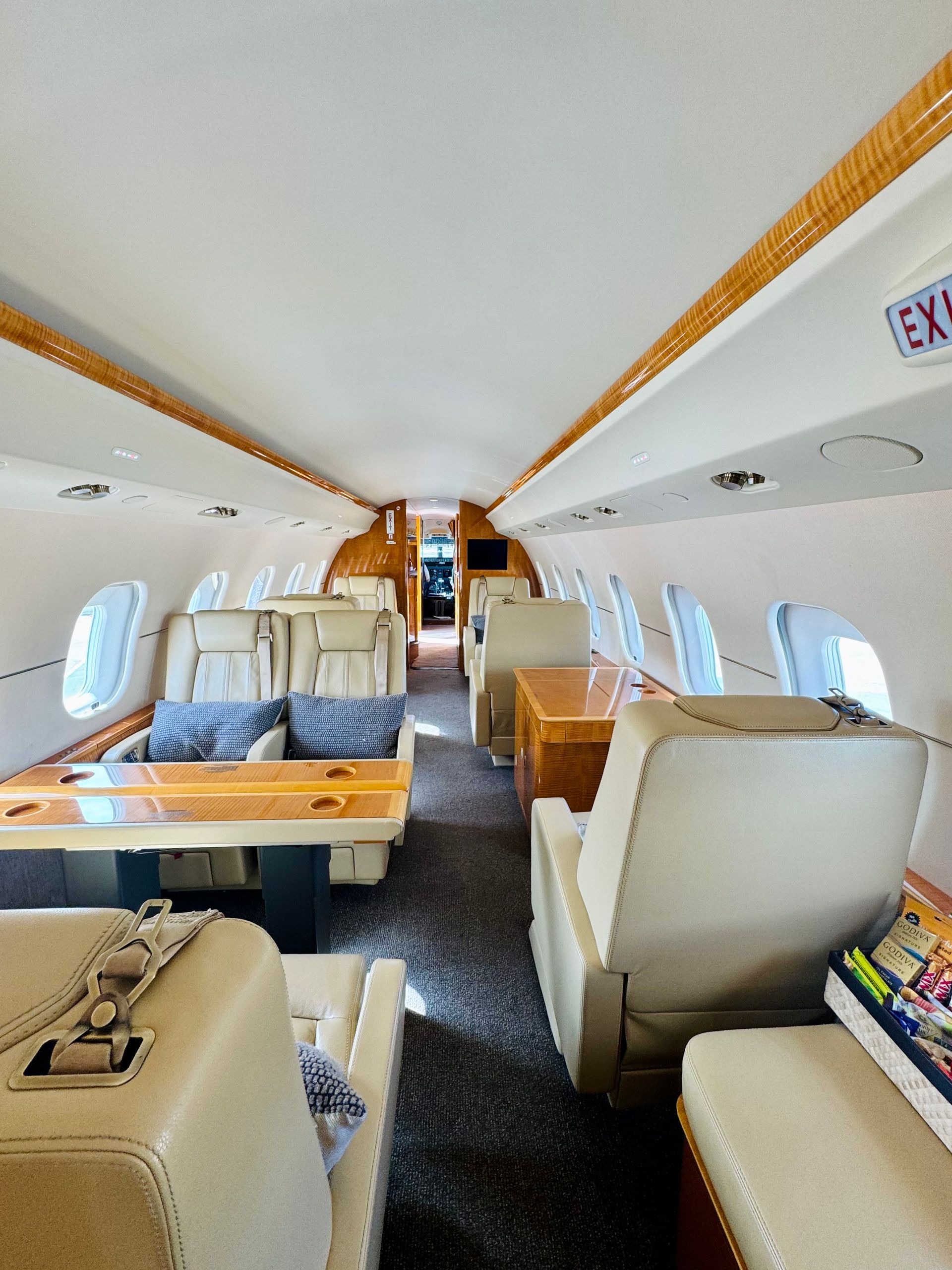 The inside of a private jet with a table and chairs