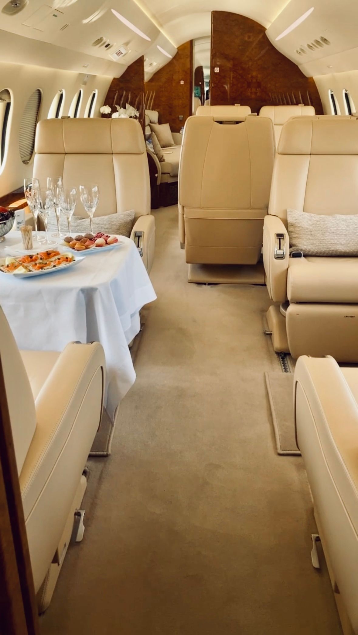 The inside of a private jet with a table and chairs.