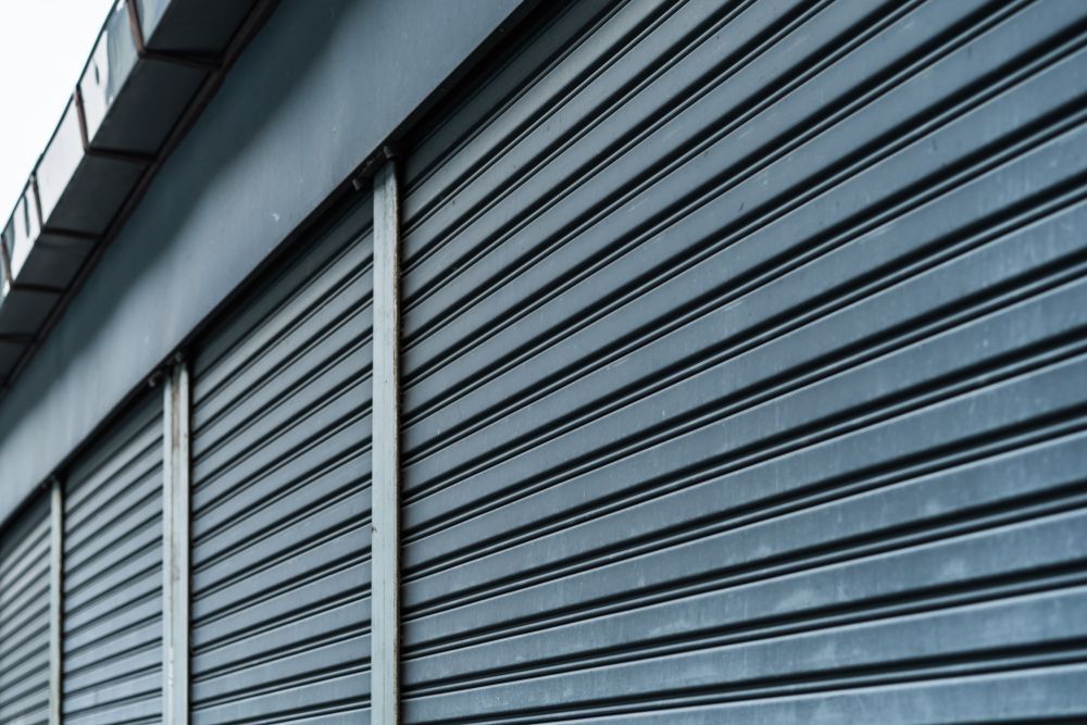 A Close Up of a Metal Garage Door on a Building — Simply Smarter Blinds in Tea Gardens, NSW