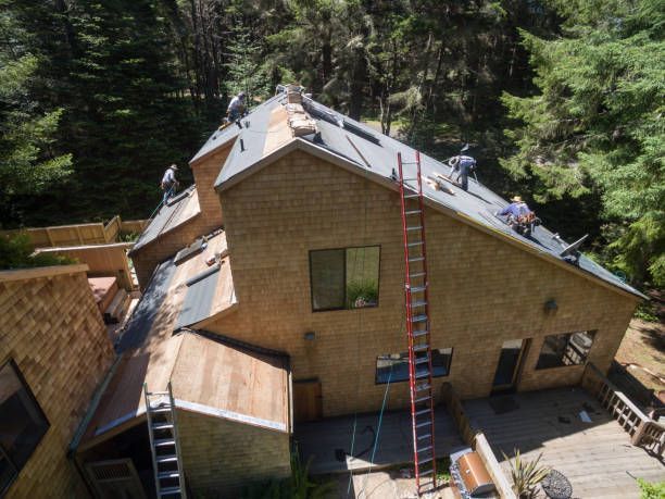 A group of people are working on the roof of a house