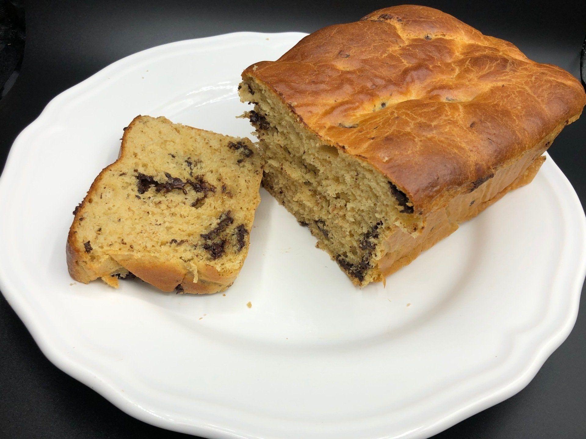 Un pain aux bananes aux pépites de chocolat sur une assiette blanche