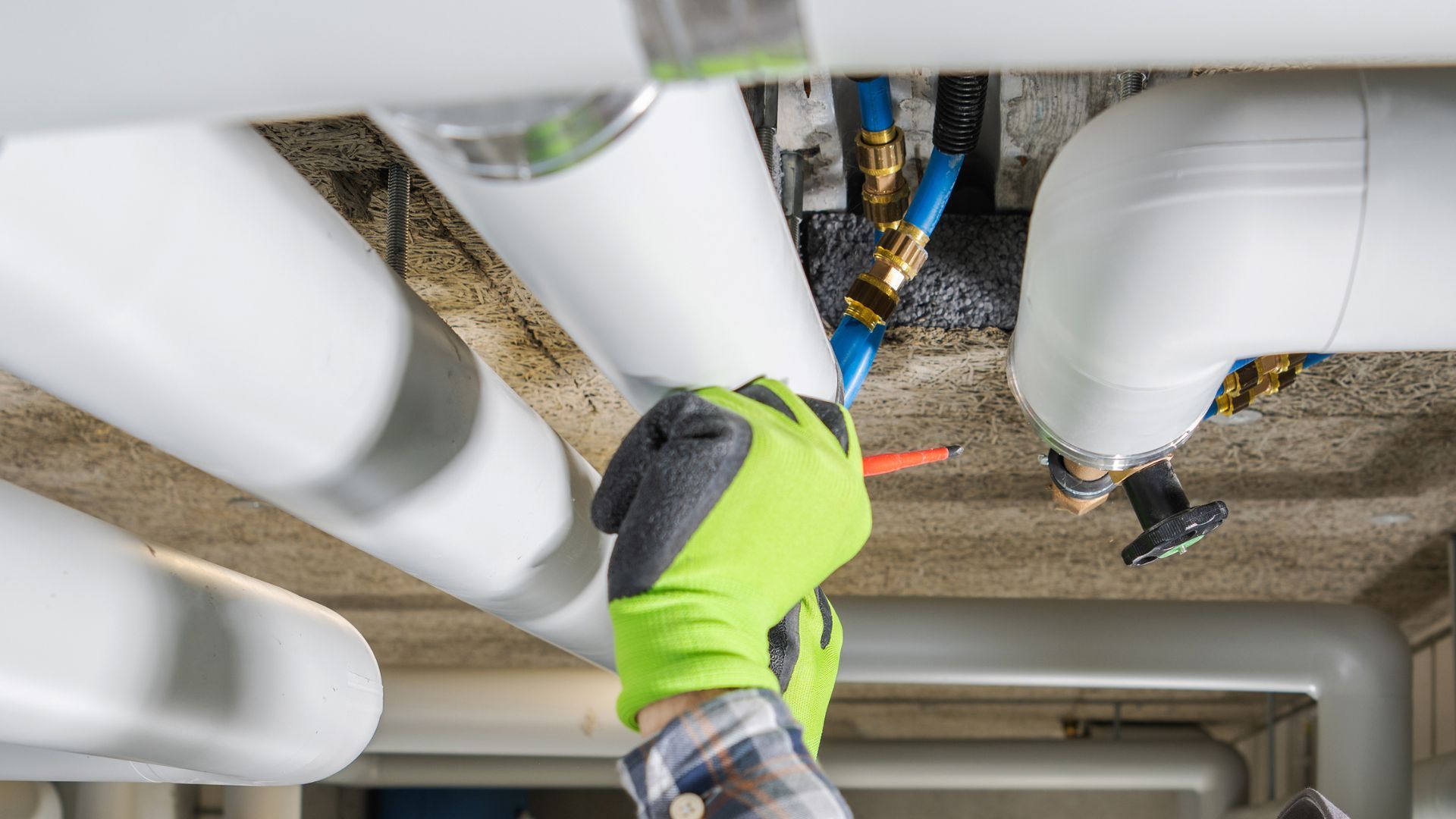A person is working on a pipe in a building.