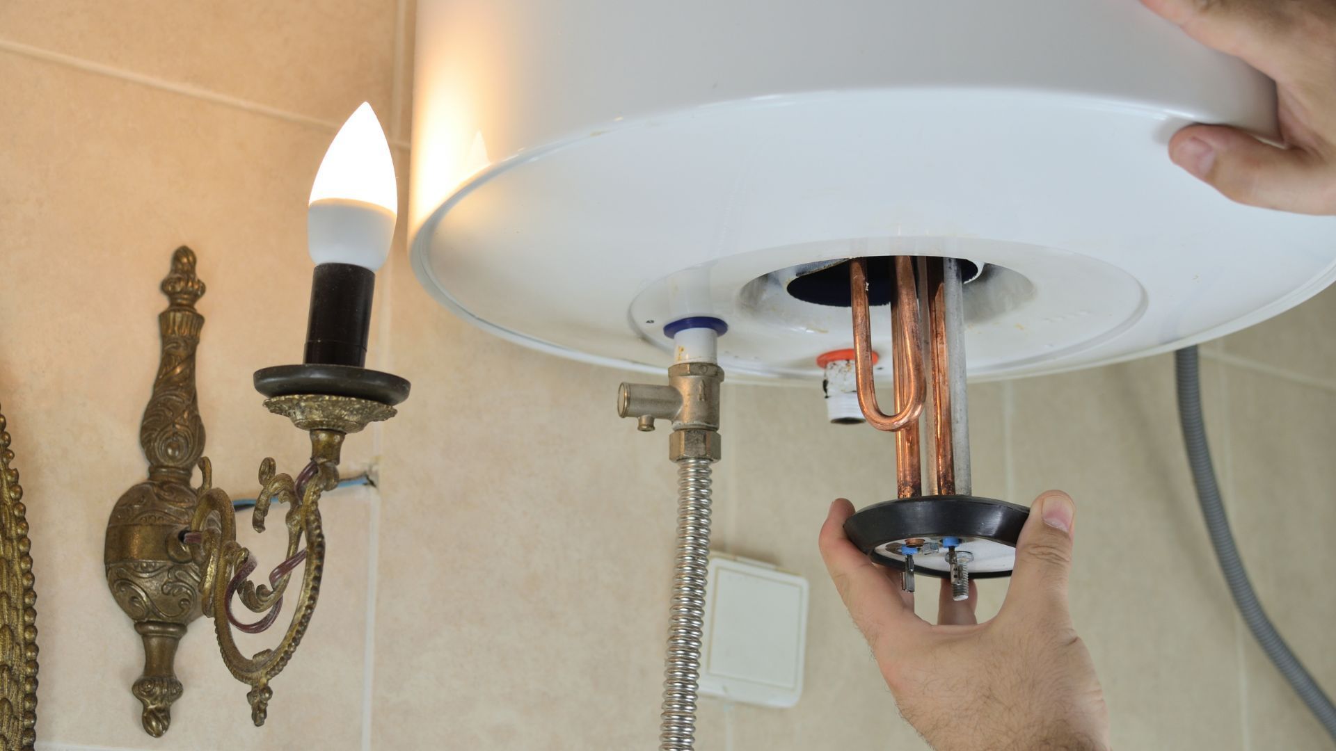 A person is fixing a water heater in a bathroom.