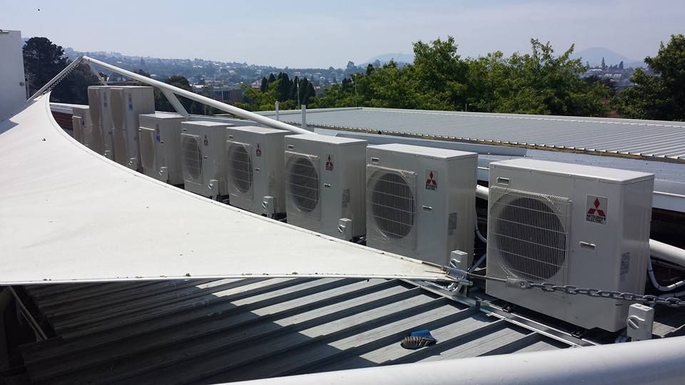A Row of Air Conditioners Are Sitting on Top of A Building- Hobart, TAS - The Heat Pump Man