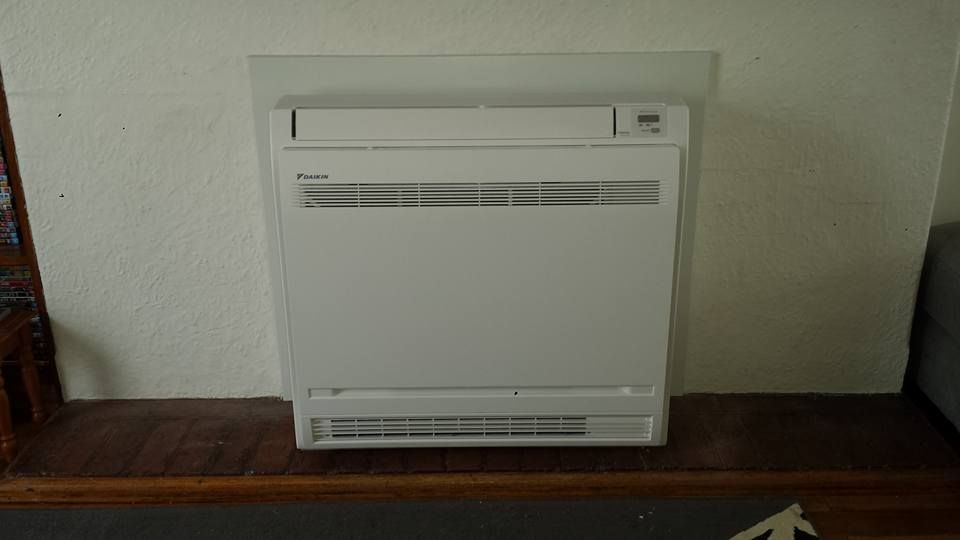 A White Air Conditioner Is Sitting on Top of A Wooden Table- Hobart, TAS - The Heat Pump Man