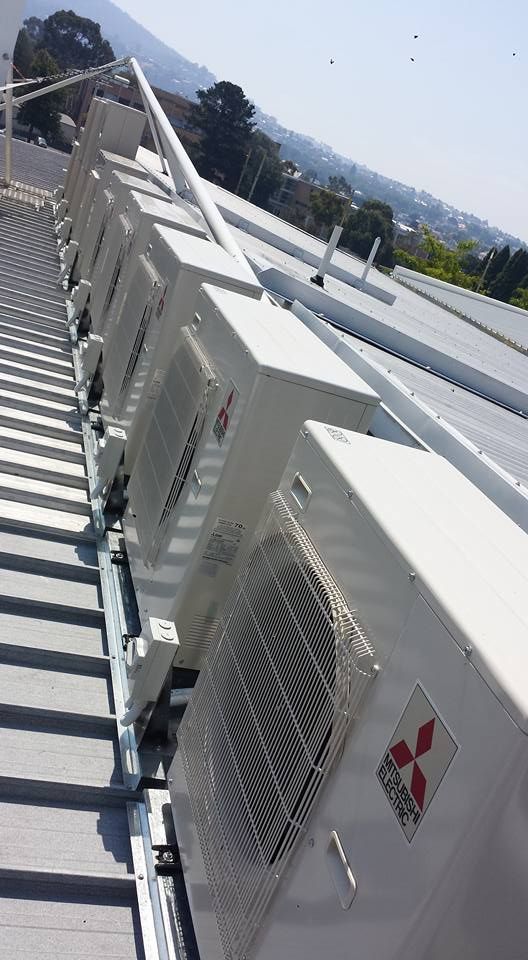 A Row of Air Conditioners Are Lined up On the Roof of A Building- Hobart, TAS - The Heat Pump Man