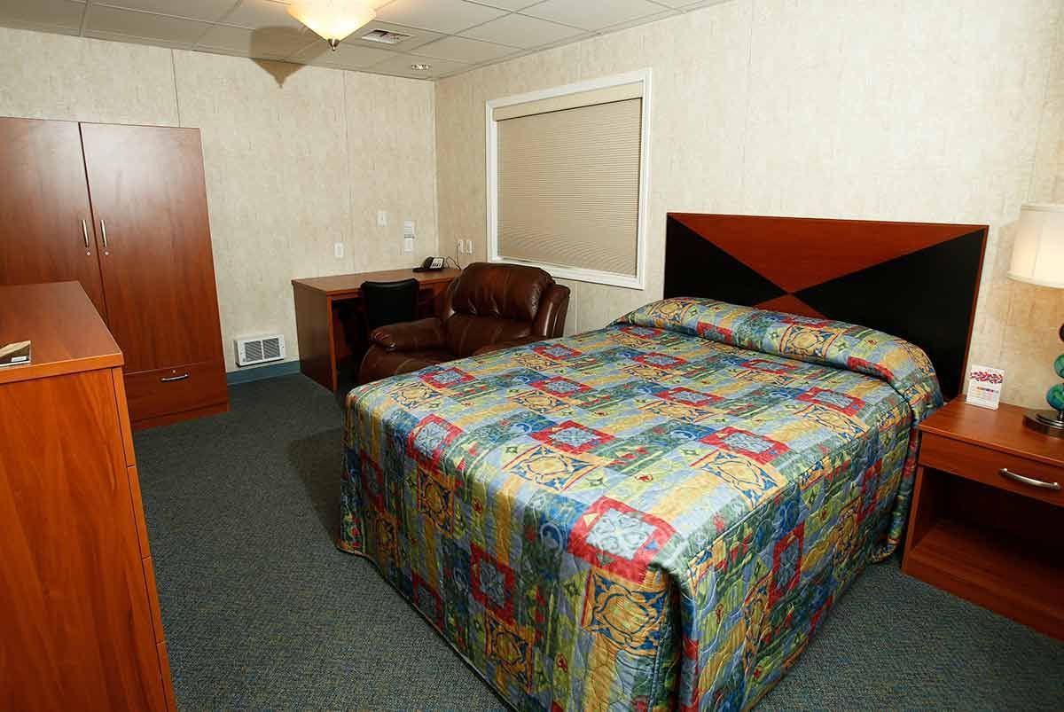 A hotel room with a bed and a chair