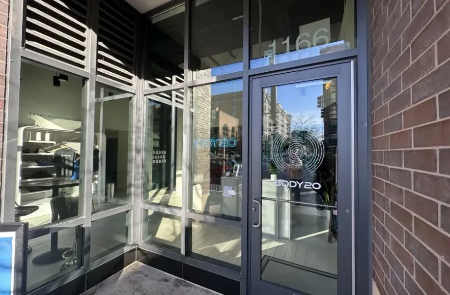 A building with a large glass door and a brick wall.