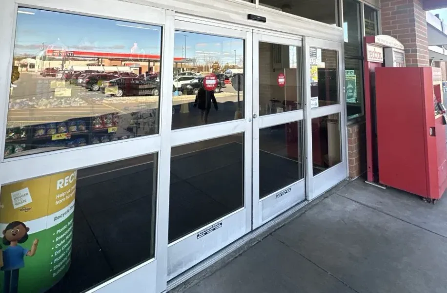 A store front with sliding glass doors and a red vending machine.