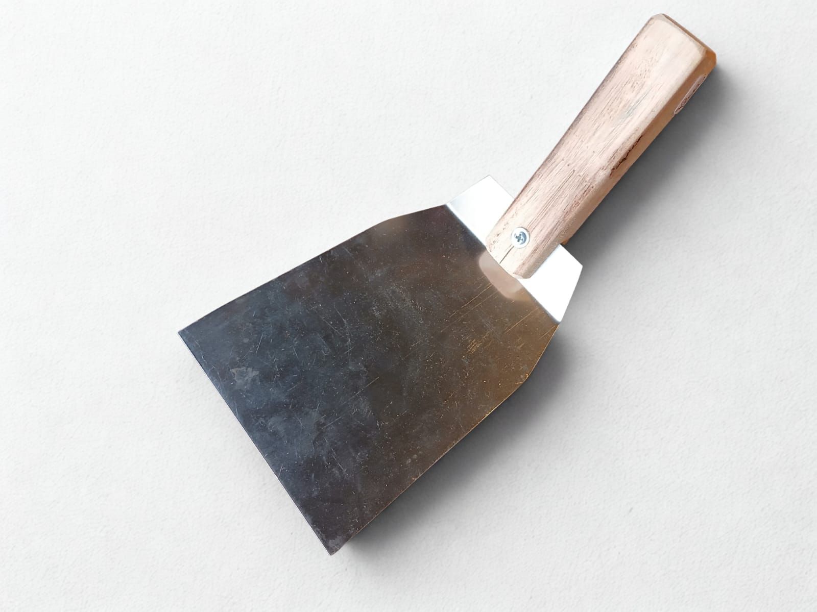 Raspador de metal con mango de madera sobre fondo blanco.