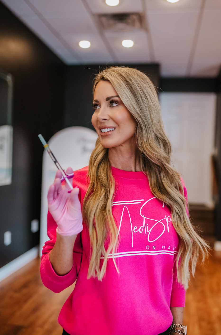 a woman holding a needle syringe at medispa on main