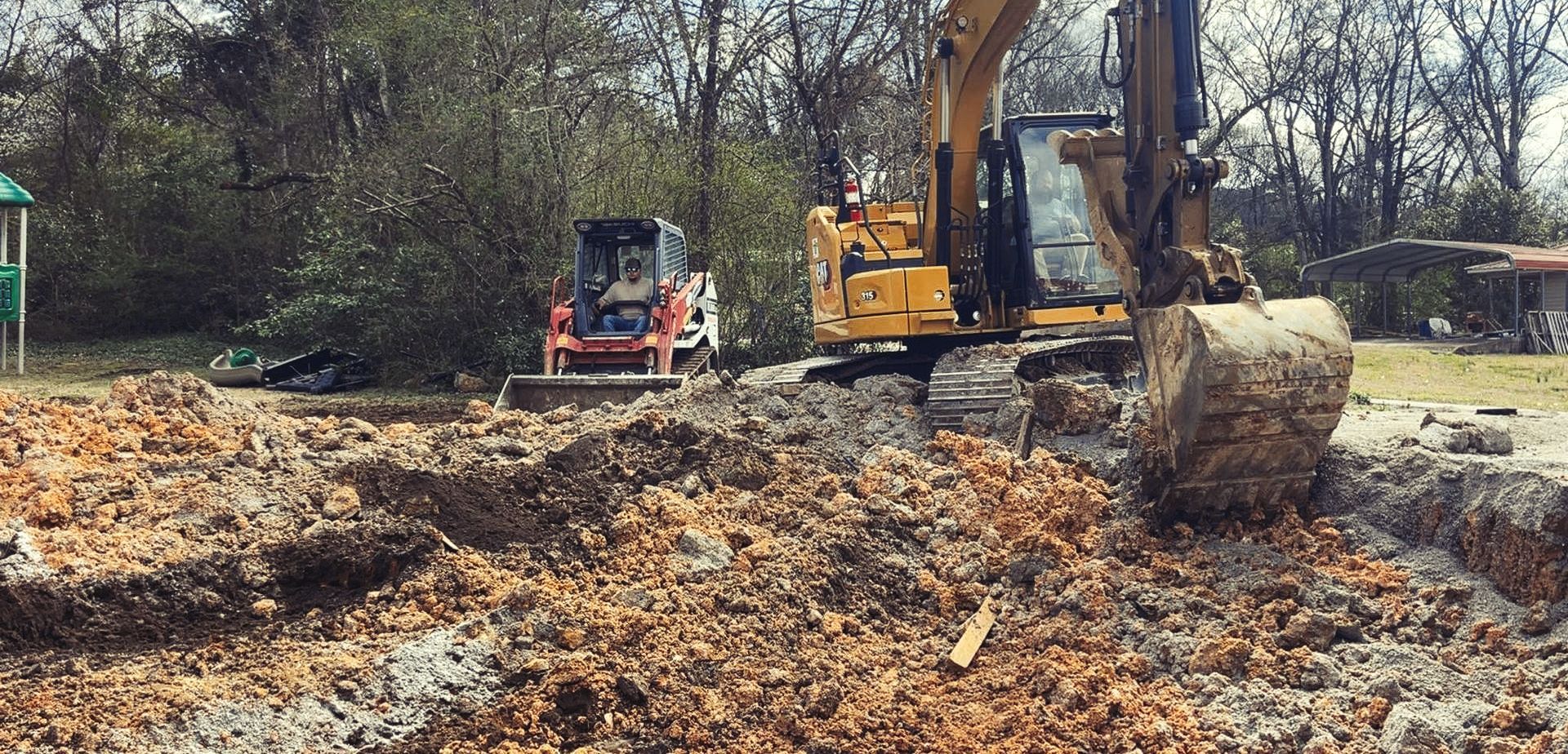 A bulldozer is digging a hole in a pile of dirt.