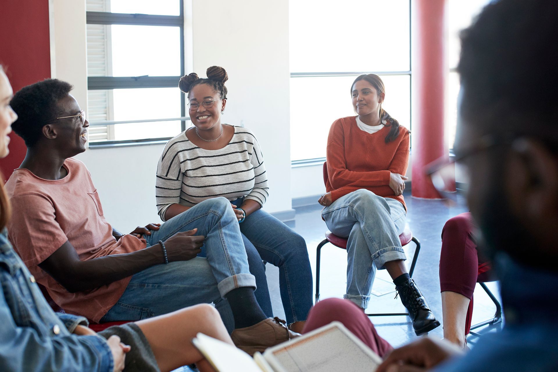 A group of people are sitting in a circle talking to each other.