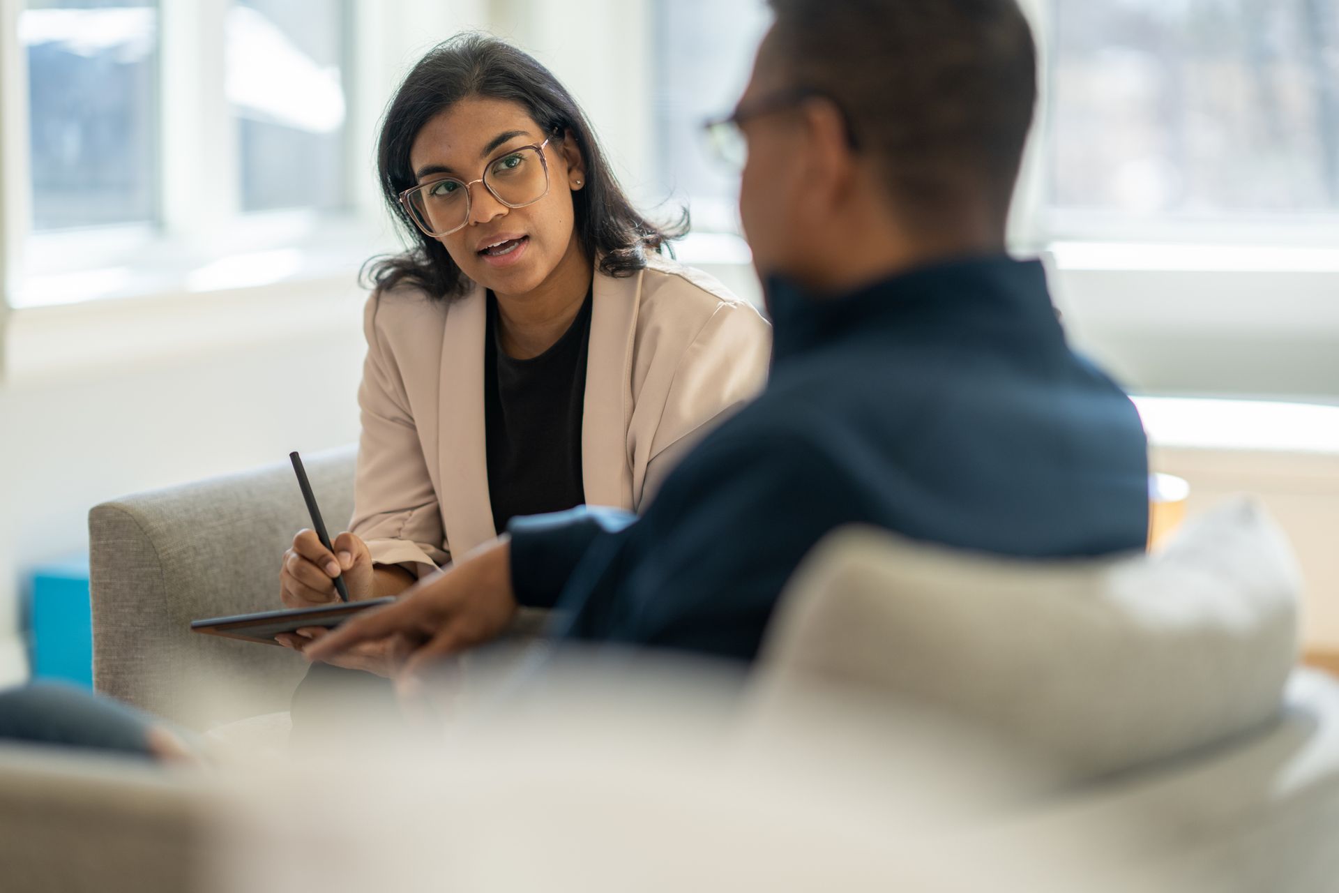 A woman is sitting at a table talking to a man.