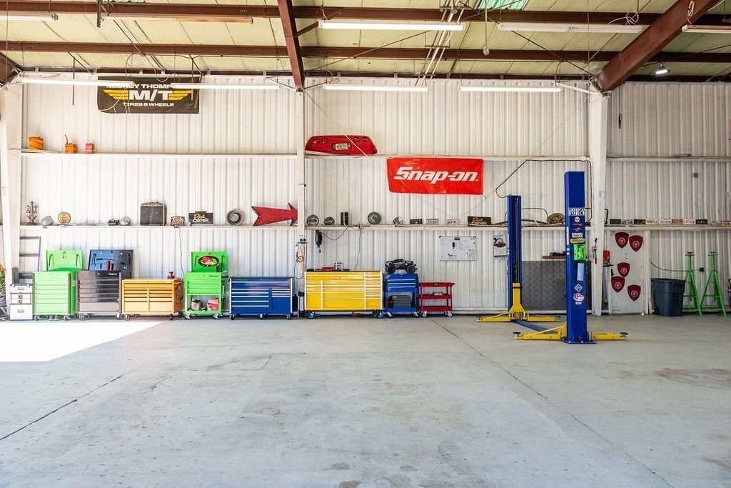 A large empty garage with a snap on sign on the wall.