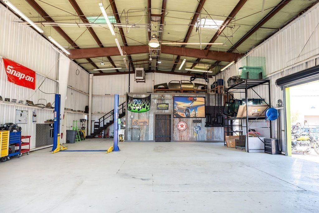 A large empty garage with a snap on sign on the wall.
