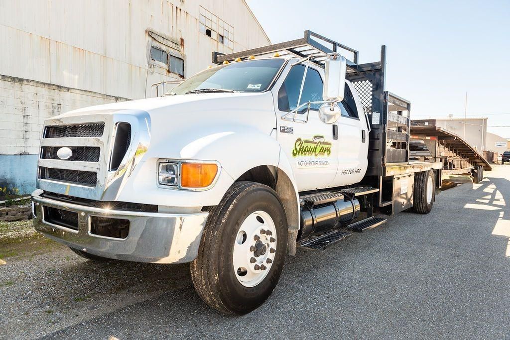 A white tow truck is parked in front of a building.