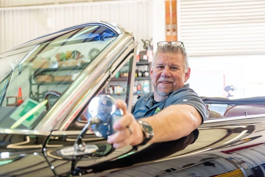 A man is sitting in the driver 's seat of a car.