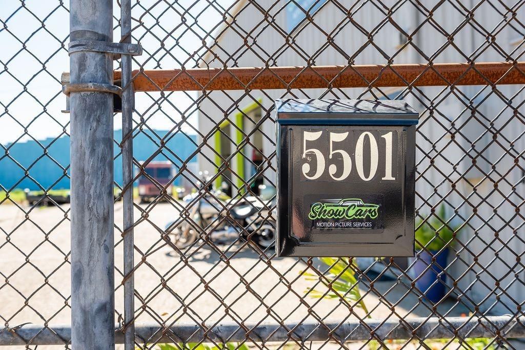 A mailbox with the address 5501 on it is behind a chain link fence.