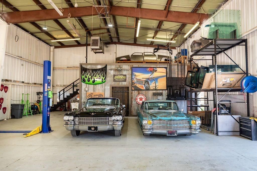 Two classic cars are parked in a garage.