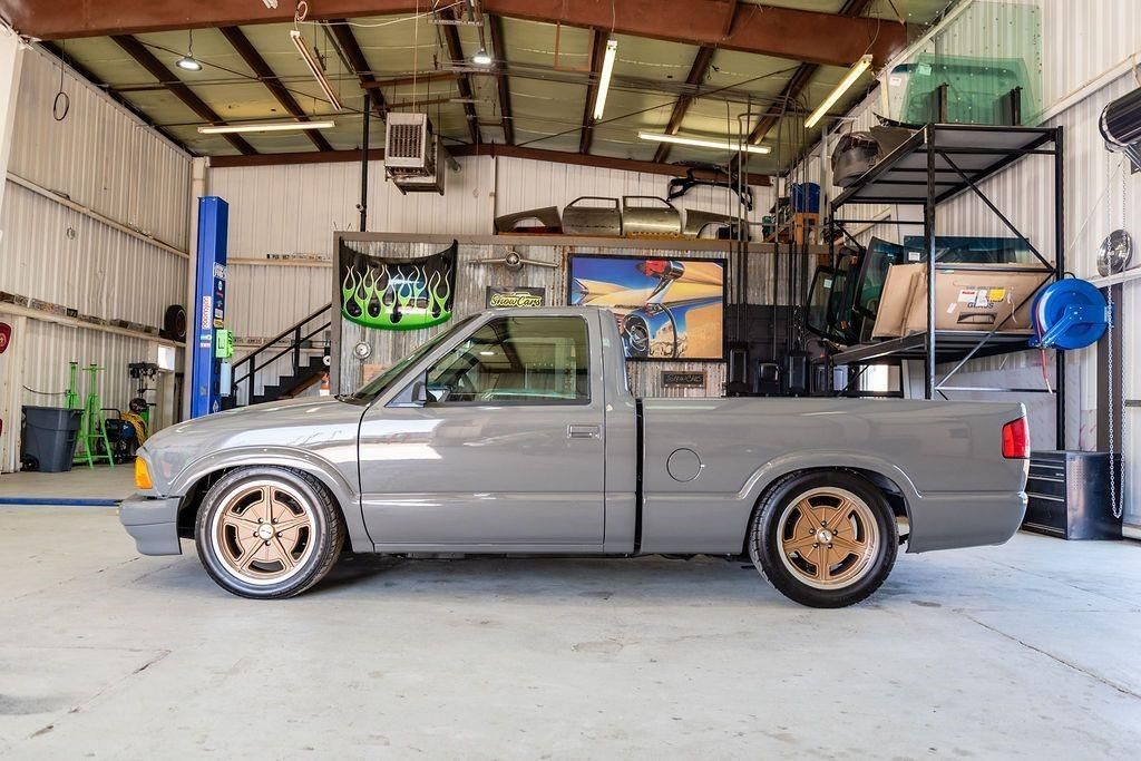 A gray pickup truck is parked in a garage.