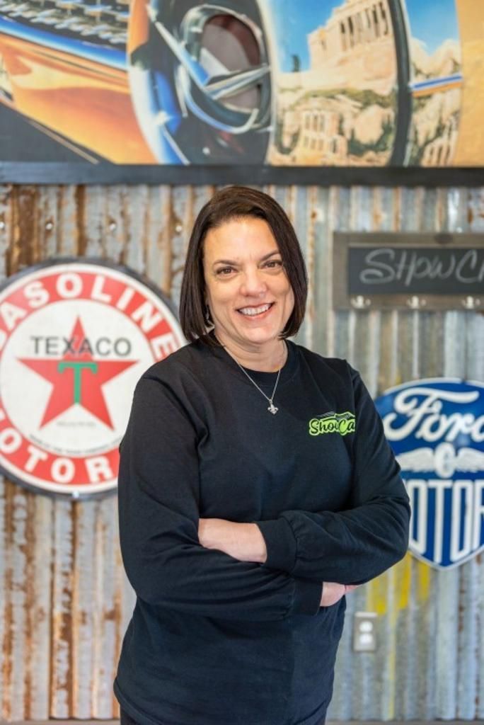 A woman is standing in front of a sign that says texaco