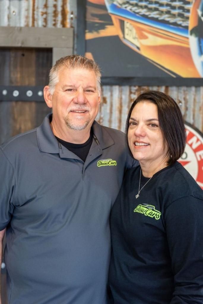 A man and a woman are posing for a picture in a room.