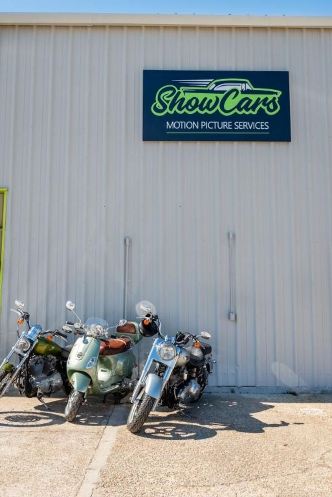 A row of motorcycles are parked in front of a building.