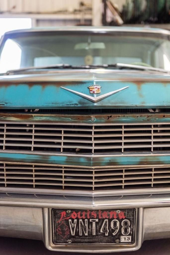 A close up of a blue car with a license plate that says vnt498