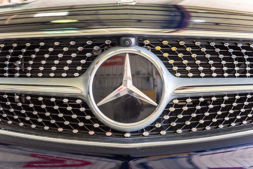 A close up of a mercedes logo on the front of a car